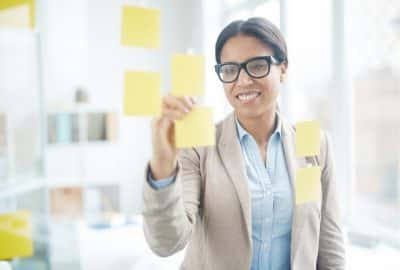 mulher colando post-it em um quadro