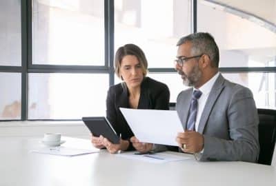 homem segurando um contrato conversa com uma mulher